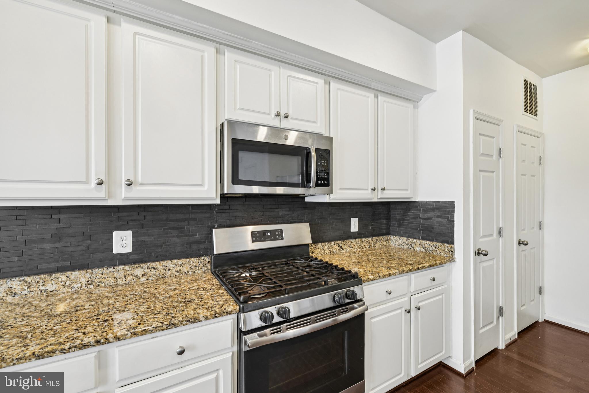 5841 Bella Marie Way Frederick, MD 21703 - Photo 14 of 45 a kitchen with granite countertop white cabinets and stainless steel appliances