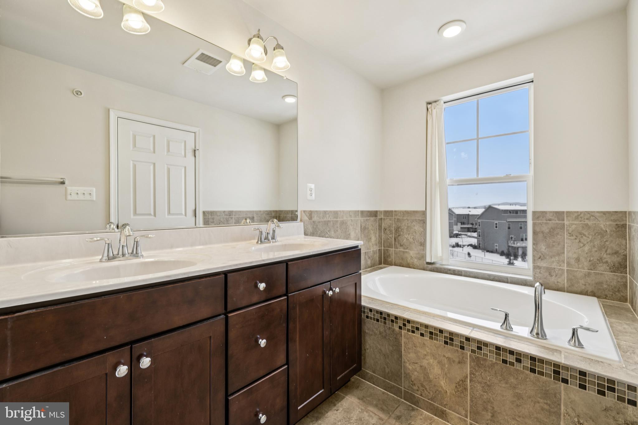 5841 Bella Marie Way Frederick, MD 21703 - Photo 26 of 45 a bathroom with a bathtub double vanity sink and a mirror