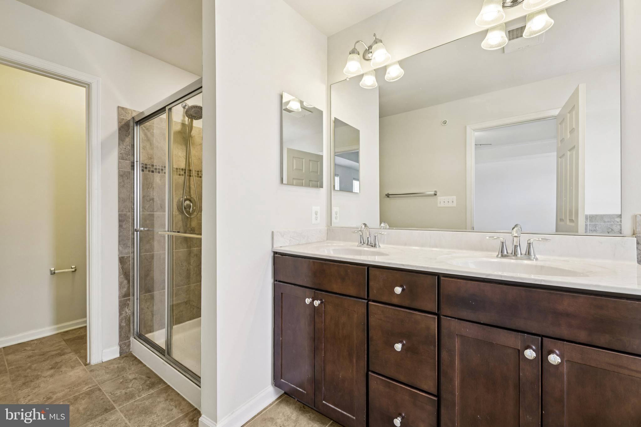 5841 Bella Marie Way Frederick, MD 21703 - Photo 27 of 45 a bathroom with a double vanity sink mirror and shower