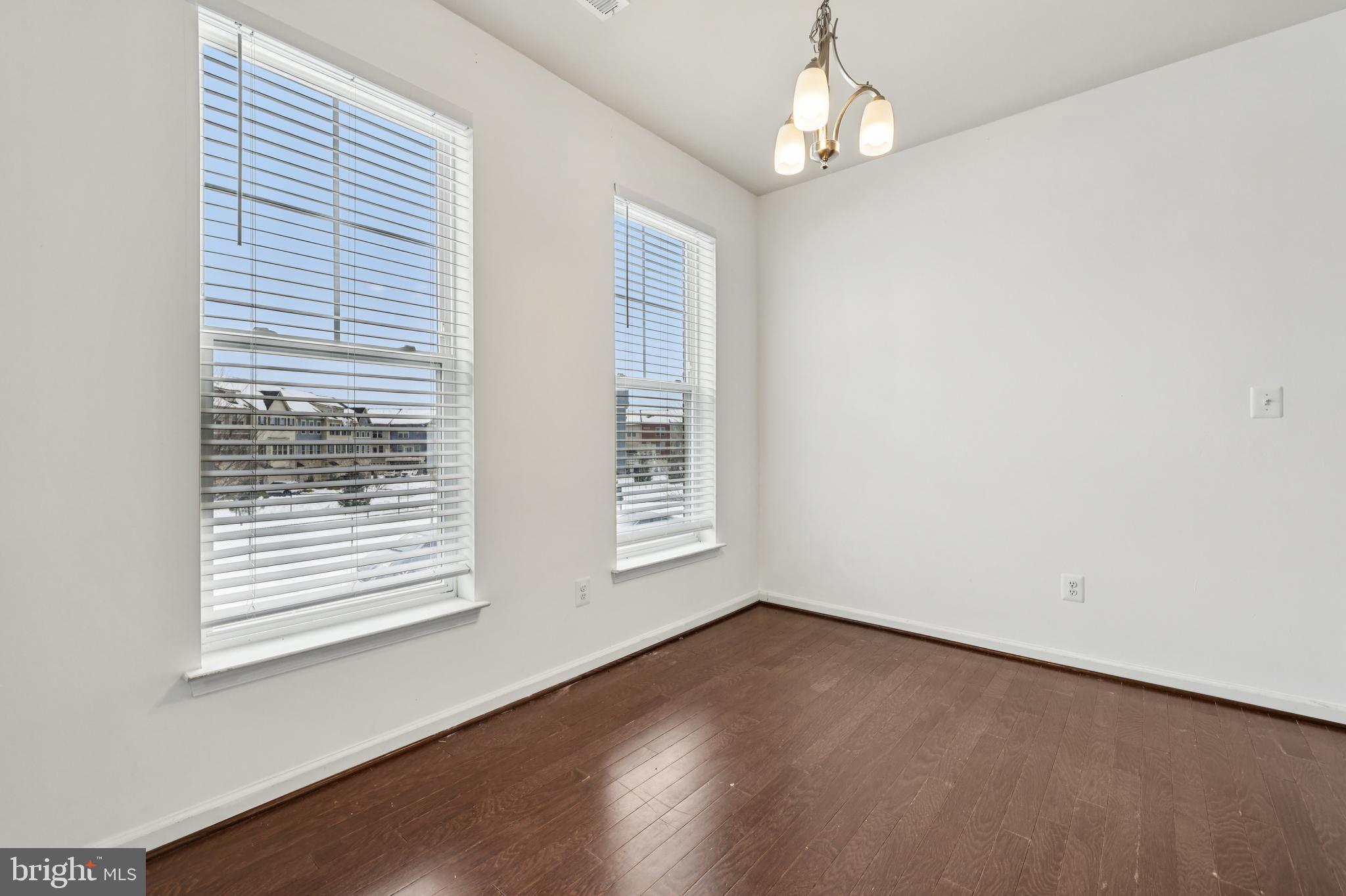 5841 Bella Marie Way Frederick, MD 21703 - Photo 10 of 45 an empty room with wooden floor chandelier and windows