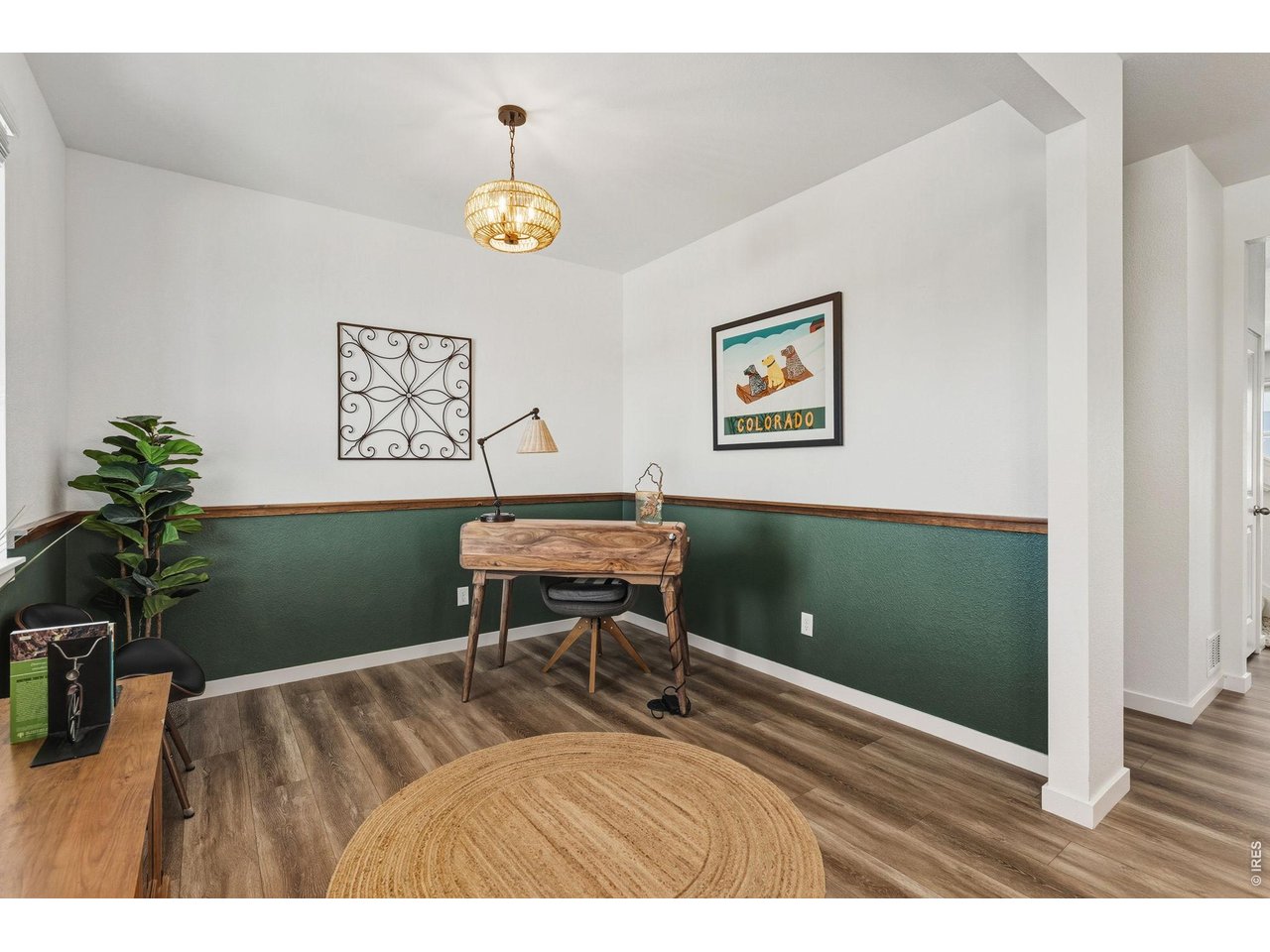 438 Bluebird Road Johnstown, CO 80534 - Photo 7 of 33 Main-floor office with wood-look flooring, two-tone accent wall with chair rail, and pendant lighting; flexible as office or den.