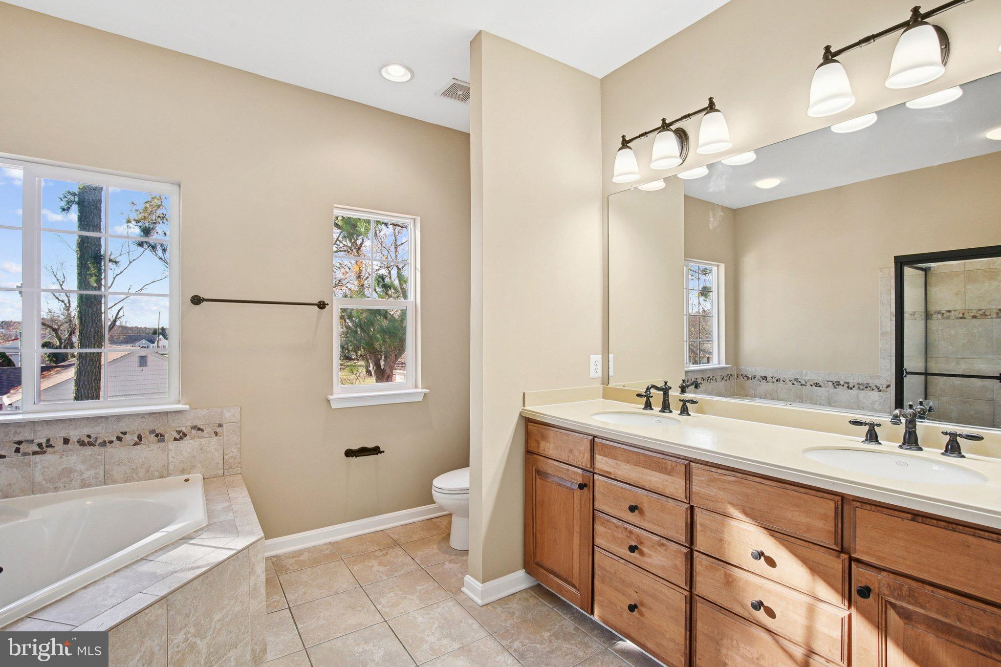 302 Appleby School Road Cambridge, MD 21613 - Photo 12 of 28 a spacious bathroom with double vanity a mirror a bathtub and a double vanity sink