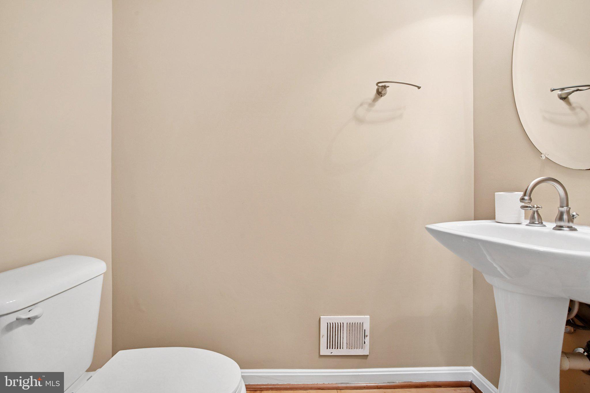 302 Appleby School Road Cambridge, MD 21613 - Photo 10 of 28 a bathroom with a toilet a sink and mirror