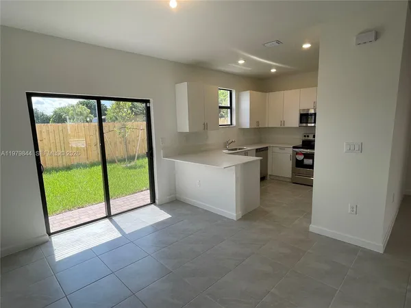a kitchen with granite countertop a refrigerator and a sink