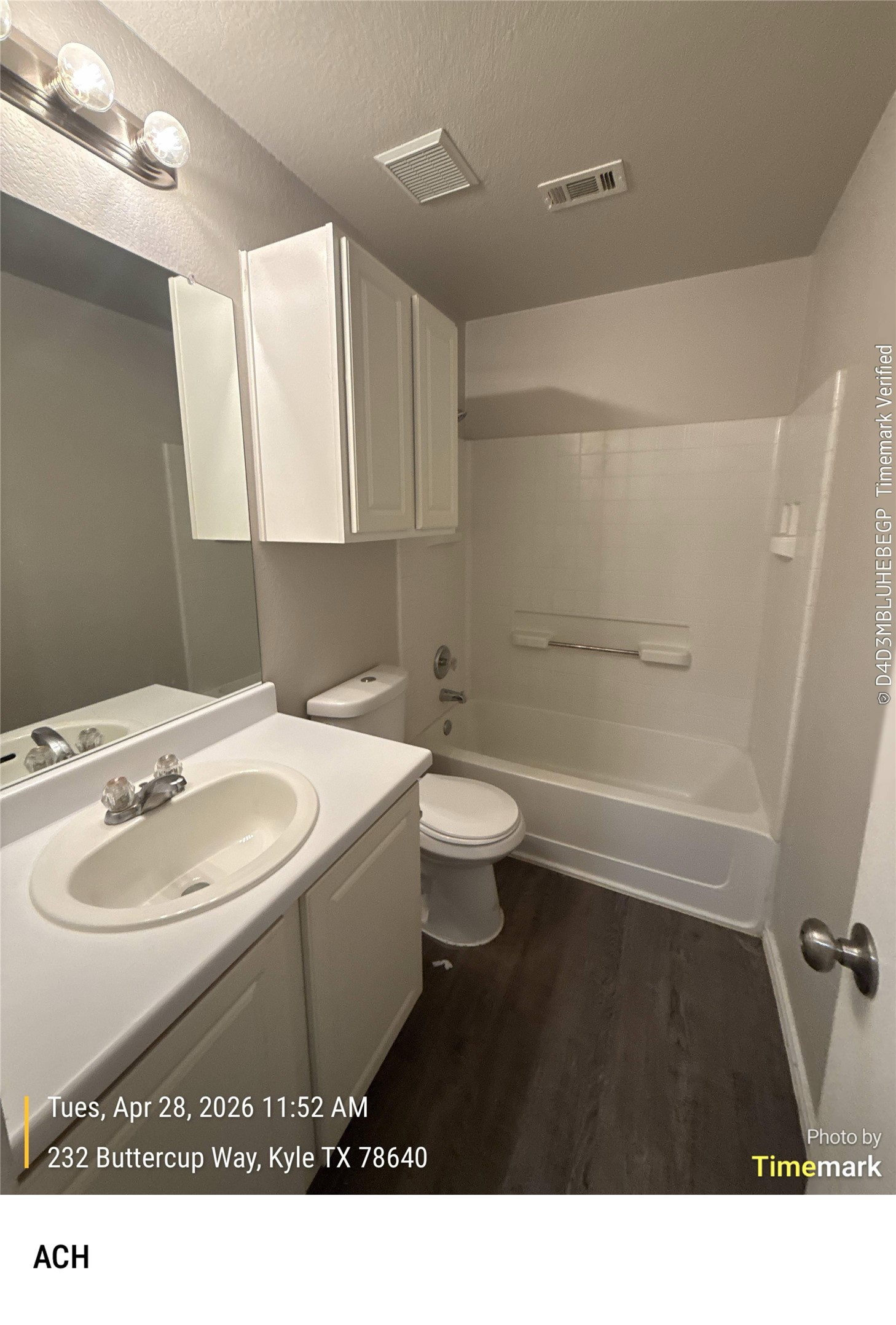 232 Buttercup Way Kyle, TX 78640 - Photo 7 of 17 Full bathroom featuring a white vanity with integrated sink, white cabinetry, a built-in bathtub with shower, and wood-finish flooring