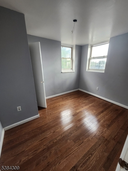 320 South Orange Avenue, Unit 3W Newark, NJ 07103 - Photo 2 of 9 an empty room with wooden floor and windows