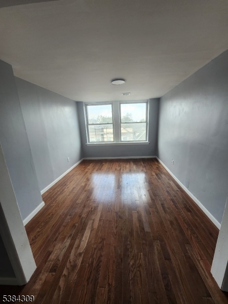 320 South Orange Avenue, Unit 3W Newark, NJ 07103 - Photo 4 of 9 an empty room with wooden floor and windows