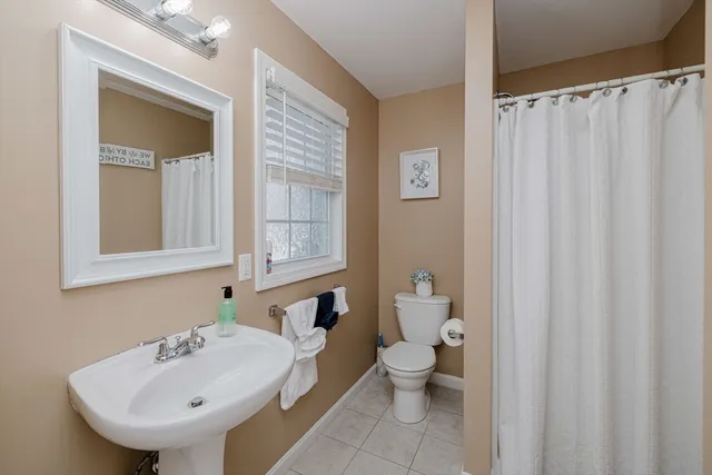 a bathroom with a toilet a sink and a window
