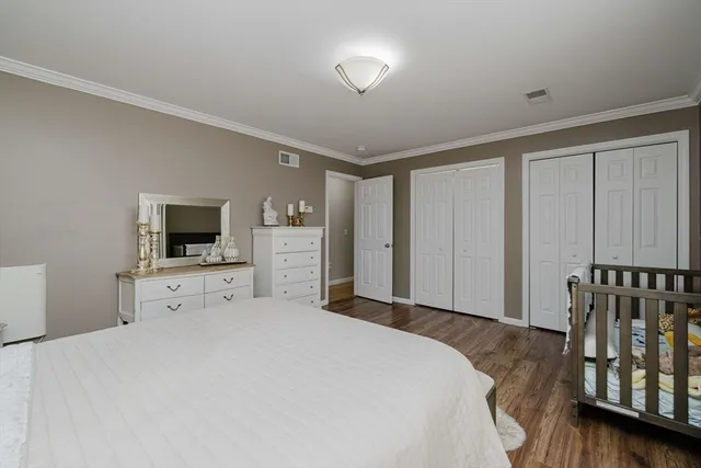 a large bedroom with a bed and a flat screen tv