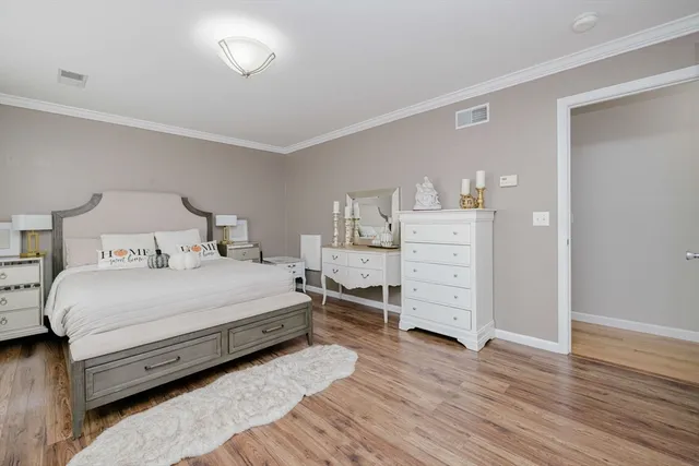 a bedroom with a bed and wooden floor
