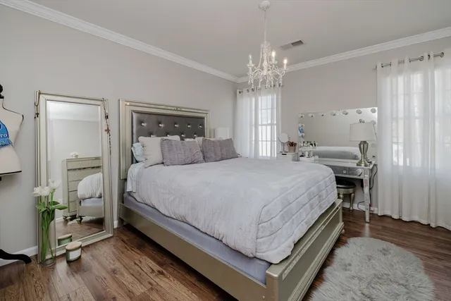 a bedroom with a bed and a chandelier