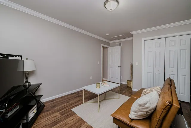 a living room with furniture and a wooden floor