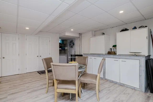 a kitchen with a dining table chairs and white cabinets