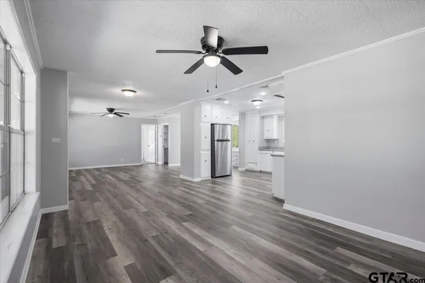 a view of empty room with wooden floor and window