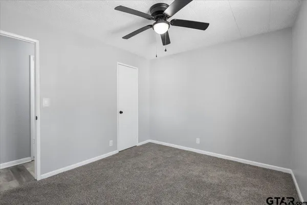 an empty room with a ceiling fan and a fan