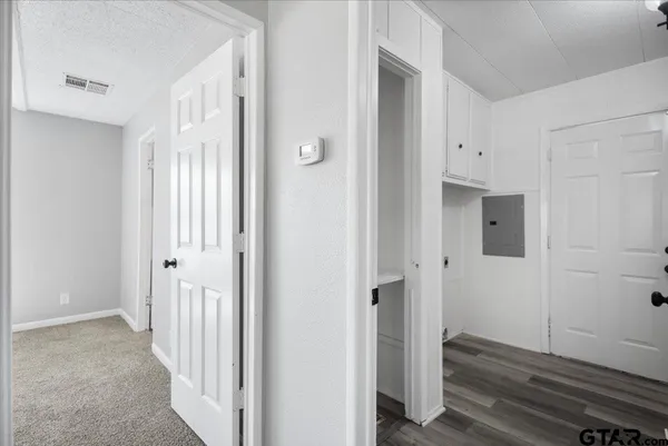 a view of a hallway with wooden floor and entryway