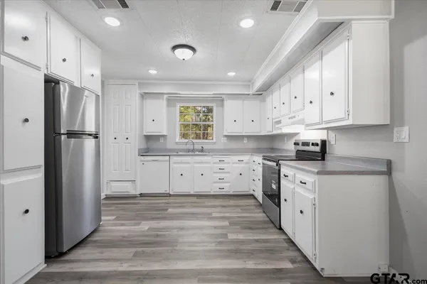 a kitchen with white cabinets and stainless steel appliances