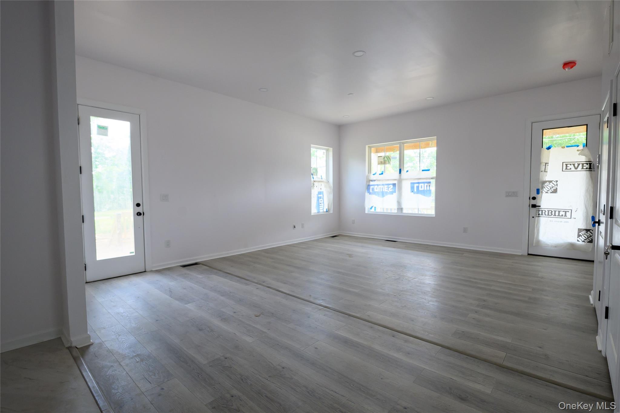 81 Silver Lake Sctn Road Middletown, NY 10940 - Photo 15 of 37 an empty room with wooden floor and windows
