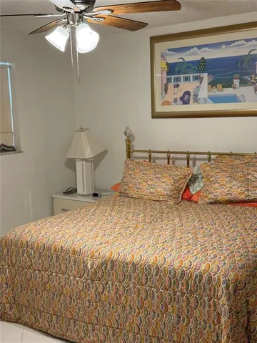 a bedroom with a bed and ceiling fan