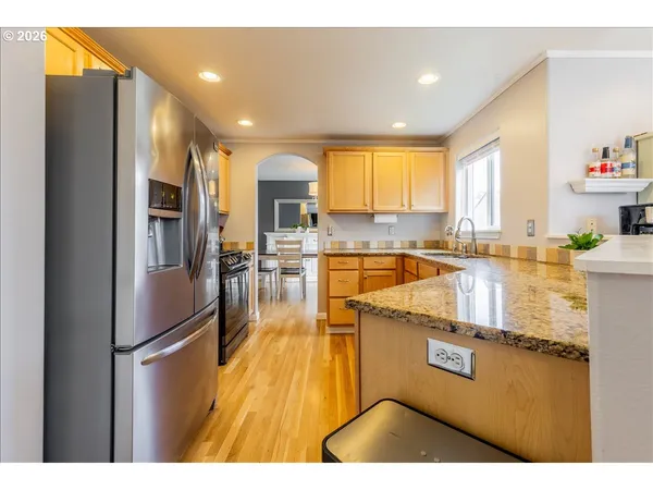 a kitchen with stainless steel appliances granite countertop a refrigerator a stove and a sink
