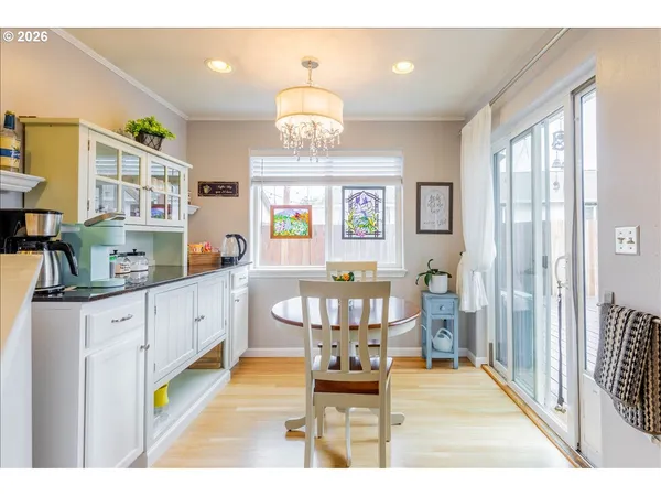 a very nice looking kitchen with granite countertop a stove a sink a dining table and chair