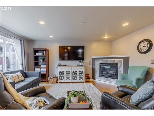a living room with furniture a flat screen tv and a fireplace