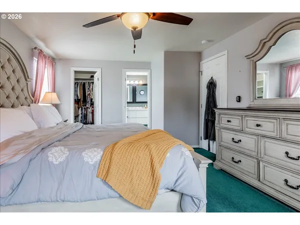 a spacious bedroom with a bed and a dresser