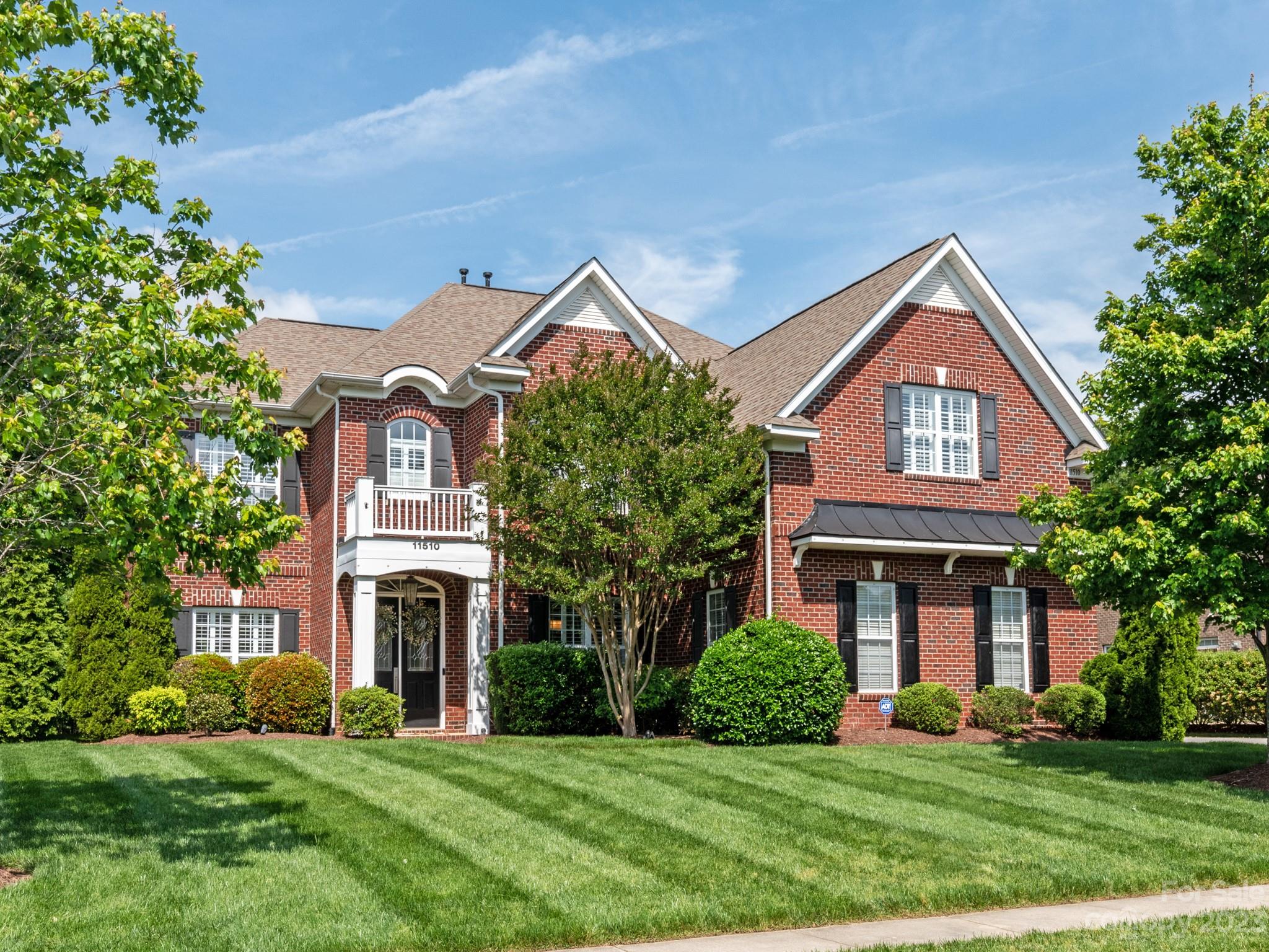 a front view of a house with a garden and yard