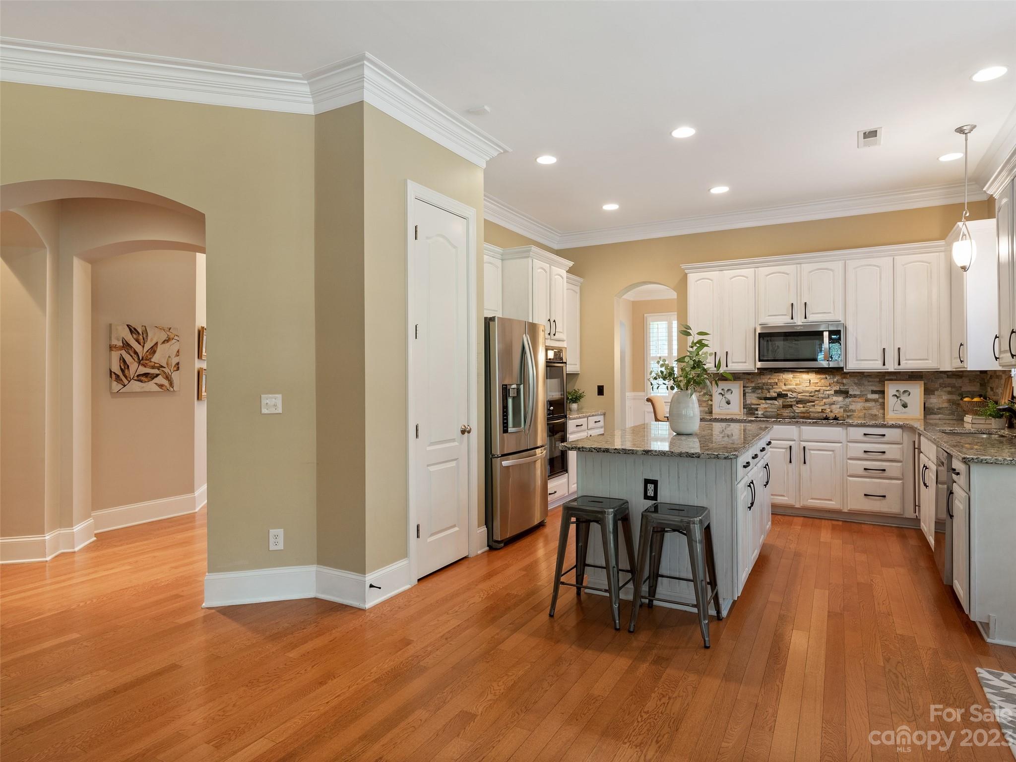 11510 Wheat Ridge Road Charlotte, NC 28277 - Photo 12 of 48 a kitchen with stainless steel appliances granite countertop a refrigerator a stove top oven a sink dishwasher and a dining table with wooden floor