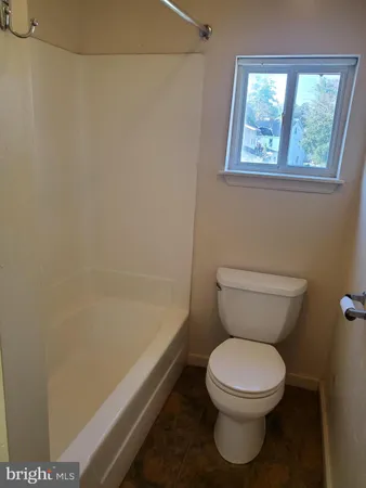 a white toilet sitting next to a bath tub