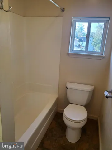 a white toilet sitting next to a bath tub