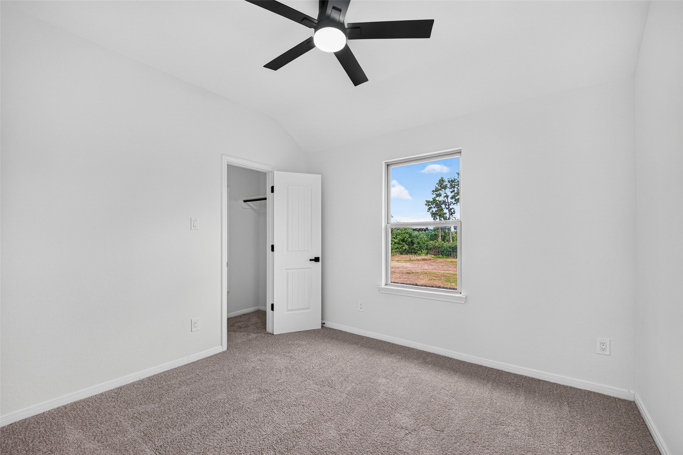 22623 Ebbets Field Drive Spring, TX 77389 - Photo 36 of 43 Secondary bedroom #3: Spacious bedroom with soft carpet flooring, a modern ceiling fan, and double doors for ample storage.