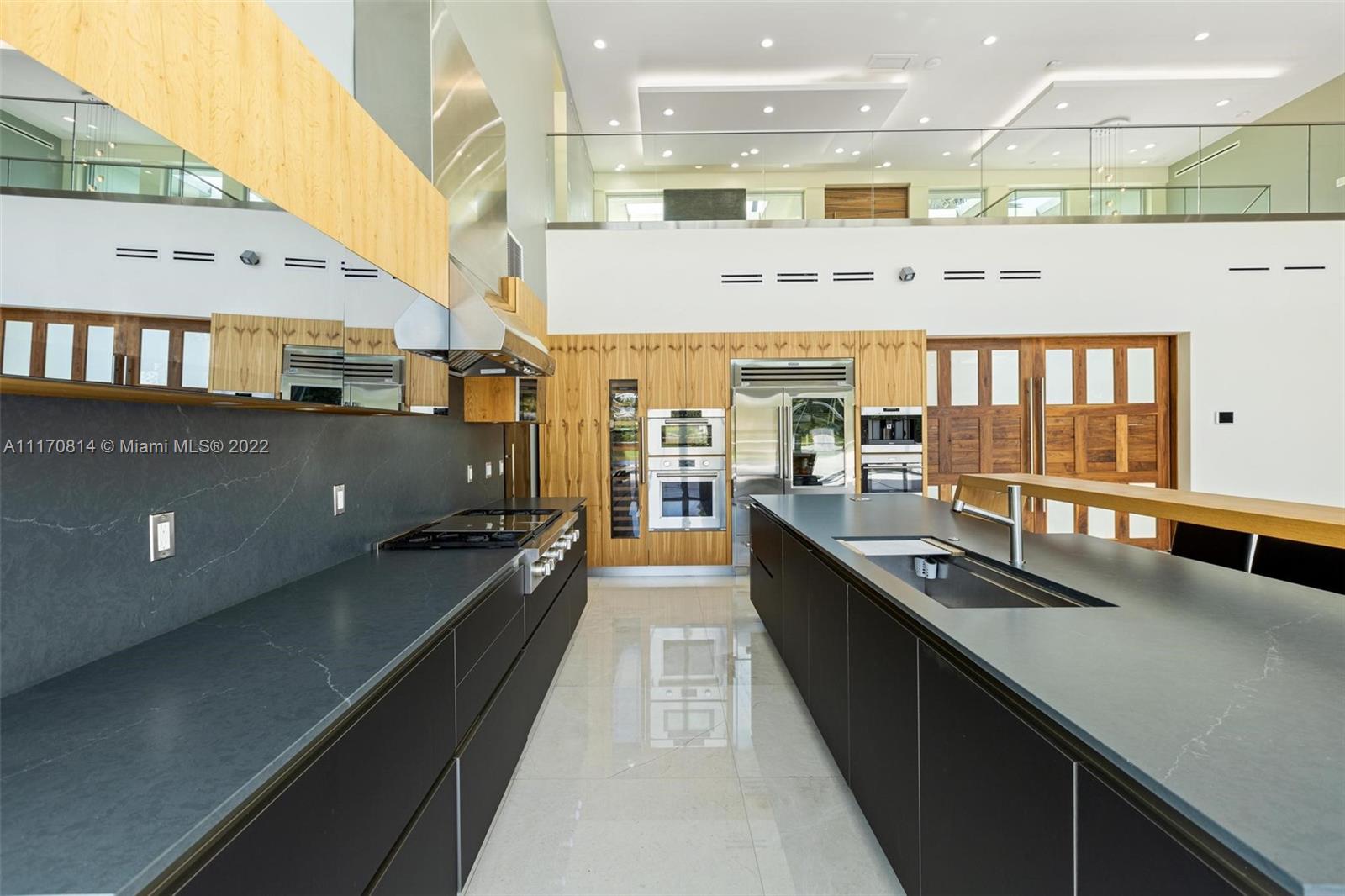 143-xx Stirling Road Southwest Ranches, FL 33330 - Photo 24 of 76 a large kitchen with stainless steel appliances a large counter top a stove a chimney a sink and a large window