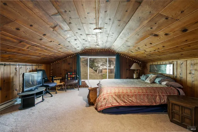 a bedroom with a bed a chandelier and flat screen tv