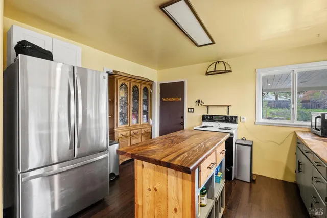 a kitchen that has a kitchen island wooden floor and stainless steel appliances