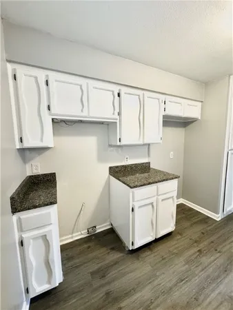 a kitchen with granite countertop wood cabinets and a stove