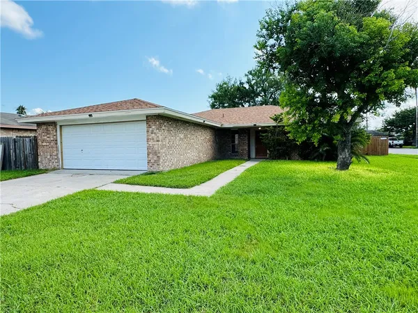a view of a house with a yard and tree