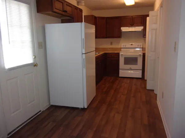 a kitchen with a refrigerator a sink and wooden floor