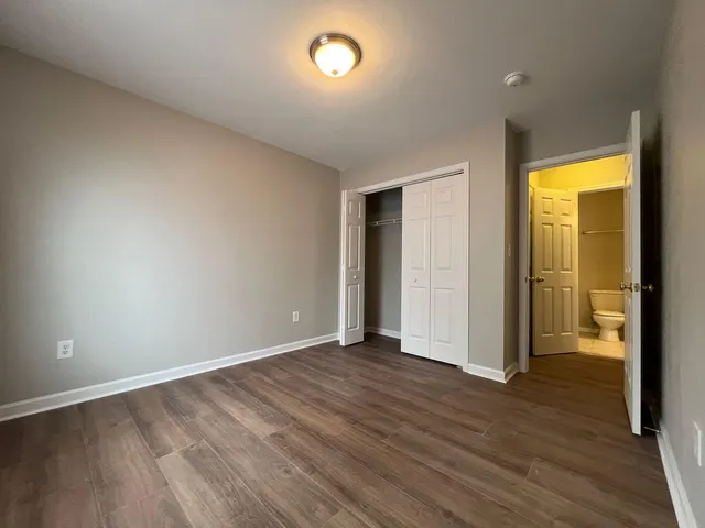 an empty room with wooden floor and a window