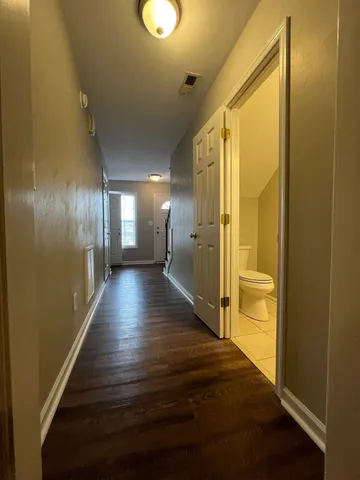 a view of a hallway with wooden floor