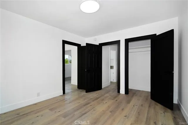 an empty room with wooden floor and closet