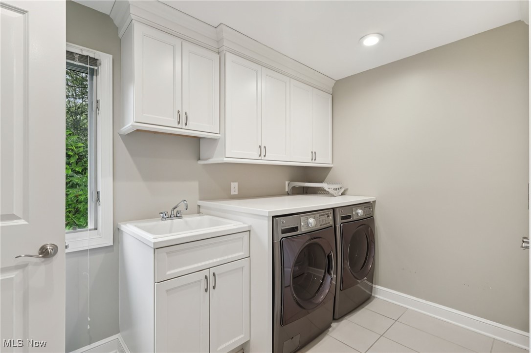 33300 South Woodland Road Cleveland, OH 44124 - Photo 28 of 50 Laundry room with light tile patterned floors, washer and clothes dryer, and cabinet space
