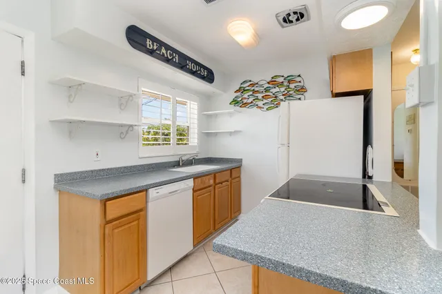 a kitchen with stainless steel appliances granite countertop a sink and a refrigerator
