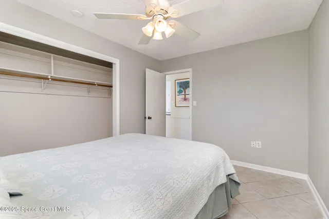 a bedroom with a bed and a ceiling fan