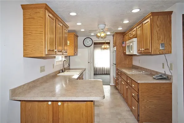 a kitchen with stainless steel appliances granite countertop a sink and a refrigerator