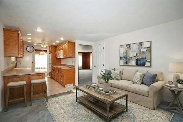 a living room with furniture and kitchen view