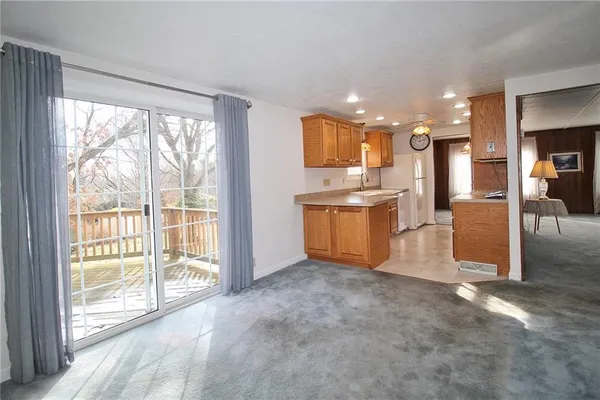 a view of a kitchen with kitchen island a large window a sink and a counter top space