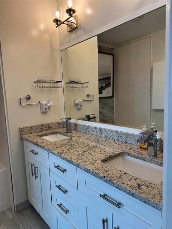 150 East Robinson Street, Unit 2409 Orlando, FL 32801 - Photo 13 of 26 a bathroom with a granite countertop sink and a mirror