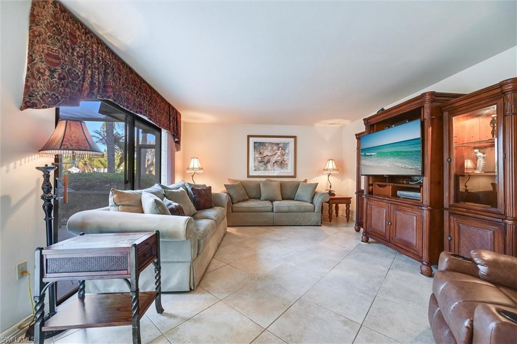 185 Lake Point Lane, Unit 8B Naples, FL 34112 - Photo 11 of 34 a living room with furniture and a flat screen tv