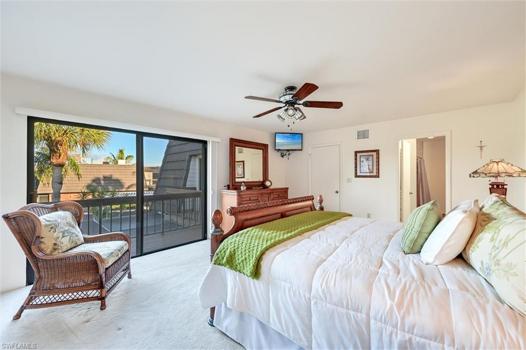 185 Lake Point Lane, Unit 8B Naples, FL 34112 - Photo 17 of 34 a bedroom with a large bed and a chandelier